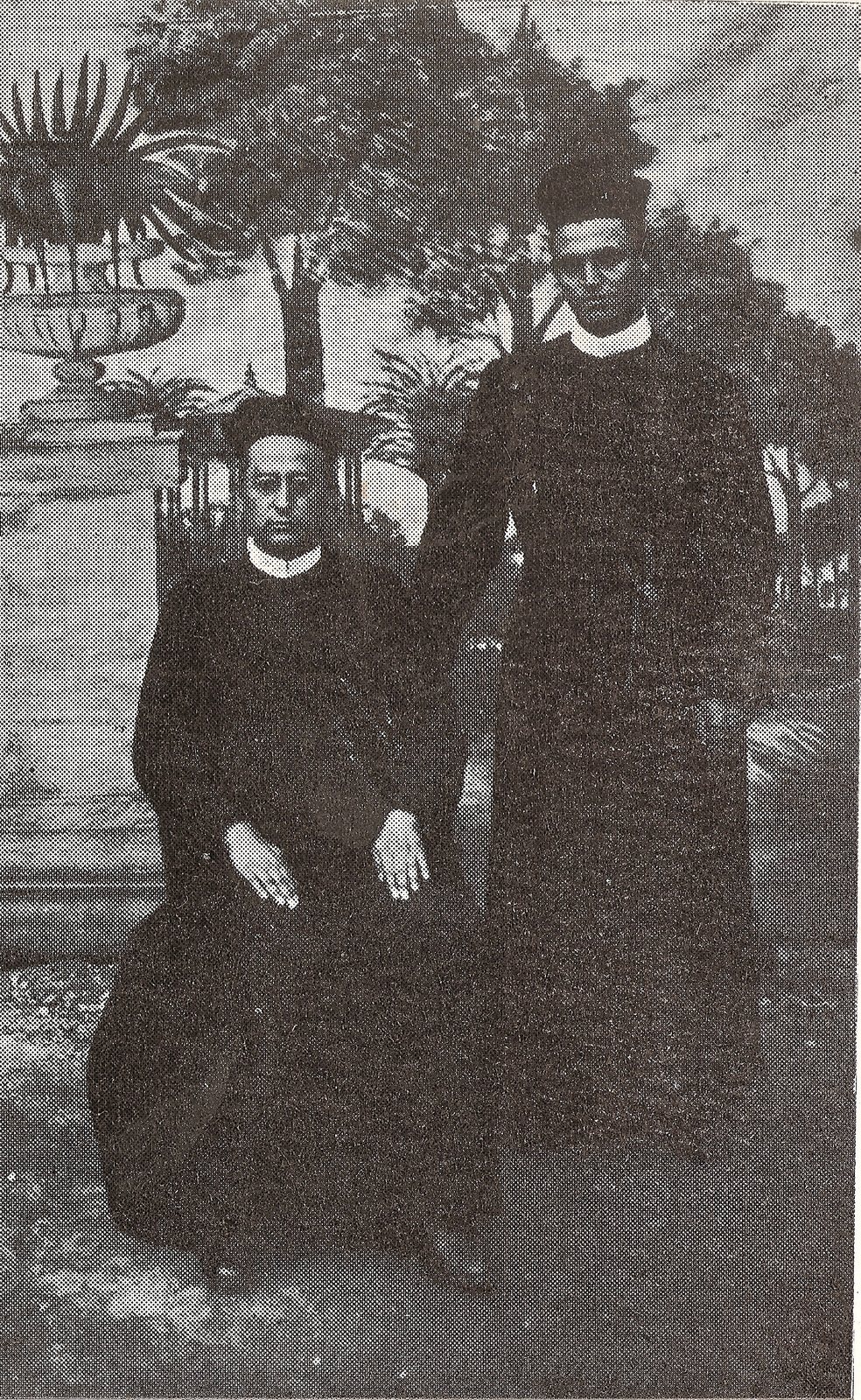 Two Redemptorist religious in a garden, one seated and one standing, in a printed reproduction.