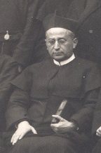 Fr Donato Jiménez seated, wearing a biretta and holding a book, in a group photograph from 1934.