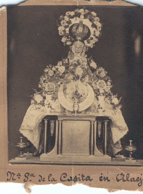 Fotografía antigua de la imagen de Nuestra Señora de la Casita en su altar, adornada con flores, con la inscripción manuscrita «N.ª S.ª de la Casita en Alaejos».